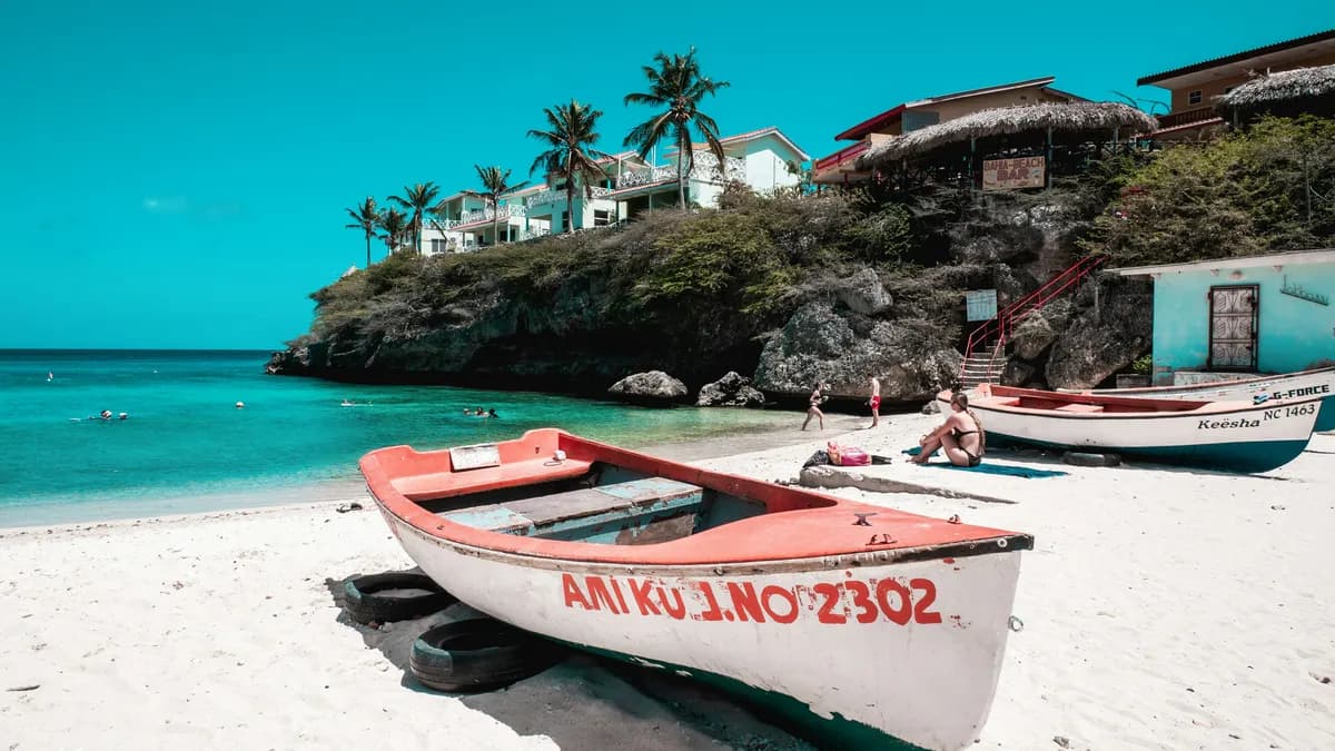 two boats on a beach with a house in the background
